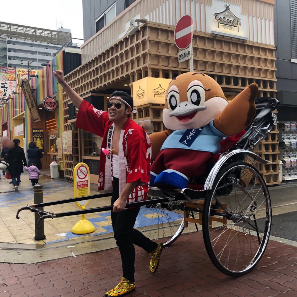 スズメの着ぐるみを人力車に乗せてイベントに参加している俥夫